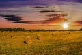 Landscape Of Field With Bales Of Hay At Sunset