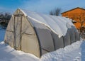 landscape with a film greenhouse snow on the greenhouse winter