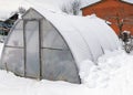 landscape with a film greenhouse, snow on the greenhouse, winter