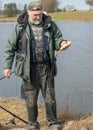 A fisherman on the shore of a lake, carp caught in the hands of a fisherman, amateur carp fishing, fishing as a hobby