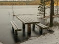 Landscape with flooded lake shore, picnic area covered with ice Royalty Free Stock Photo