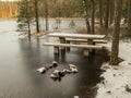 Landscape with flooded lake shore, picnic area covered with ice Royalty Free Stock Photo