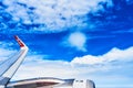Landscape of fluffy white clouds on a dark blue sky with a part of an airplane. View from the plane at high altitude Royalty Free Stock Photo