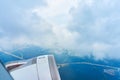 Landscape of fluffy white clouds on a dark blue sky with a part of an airplane. View from the plane at high altitude Royalty Free Stock Photo