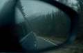 Landscape of foggy forest in the side view mirror reflection of car Royalty Free Stock Photo