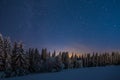 Landscape of a forest covered in trees and snow under a starry sky in the night Royalty Free Stock Photo