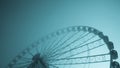 Blue-tinted image of a large ferris wheel on a cold morning Royalty Free Stock Photo