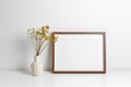 Landscape frame mockup in white minimalistic room interior with dry flowers. Royalty Free Stock Photo