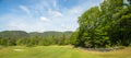 Landscape on a golf course with green grass, trees, beautiful blue sky, panorama Royalty Free Stock Photo