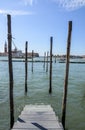 Landscape of gondolas marina with wooden beams of mooring posts in the water canal in Venice, Italy Royalty Free Stock Photo