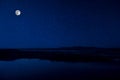 Landscape of gorgeous full moon over the snow-capped mountains reflected in the lake or mysterious night sky with full moon. Royalty Free Stock Photo
