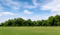 Landscape of grass field and green environment public park with blue sky. Beautiful summer landscape background Royalty Free Stock Photo