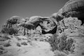 Landscape grayscale scene of Double O Arch in Arches National Park under gray sky Royalty Free Stock Photo