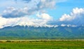 Landscape of green fields with snow-capped peaks mountains in Calimani, Romania Royalty Free Stock Photo