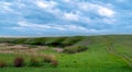 Landscape with green grass and blue sky. road goes on top of the hills. sky with blue clouds in rural. spring landscape Royalty Free Stock Photo