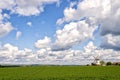 Landscape with green grass, cloudy sky and windmill Royalty Free Stock Photo