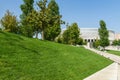 Landscape with green grass, ornamental trees and white fasade stadion. Public landscape ÃÂity park `Krasnodar` or `Galitsky park`