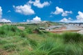 Landscape of green grass and small hills with cloud sky