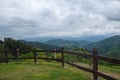 Landscape with green meadows and wooden fence with mountains