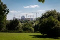 Landscape with green trees against the background of the construction of a new microdistrict. Royalty Free Stock Photo