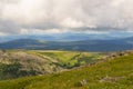 Landscape of green valley flooded with light with lush green grass, mountains, covered with stone and hills, a fresh summer day u Royalty Free Stock Photo