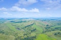 Landscape of green valley flooded with light with lush green grass, mountains, covered with stone and hills, a fresh summer day Royalty Free Stock Photo