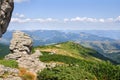 Landscape of high mountains with huge stones on top of the hillside and hills with cloudy sky. Carpathian mountains in summer Royalty Free Stock Photo