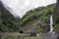 Landscape with a highway, mountain tunnel and a waterfall