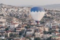 Landscape with hot air balloon that flying low over the city. Famous Turkish region Cappadocia with mountains and cave Royalty Free Stock Photo