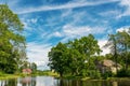 Landscape with house, lake, trees and sky