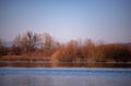 Landscape with a huge lake at the end of the autumn season. rocky mountains and high forests on the distant horizon. silhouettes o Royalty Free Stock Photo