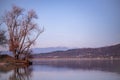 Landscape with a huge lake at the end of the autumn season. rocky mountains and high forests on the distant horizon. silhouettes o Royalty Free Stock Photo