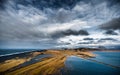 Landscape in Iceland with Ocean Water, Rocks and Black Sand Beach. Cloudy Sky and Road. Royalty Free Stock Photo