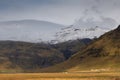 Landscape in Iceland. Wild nature, mountains, houses, grass, snow and clouds