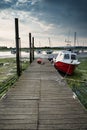 Landscape image of boats mored to jetty in harbor during Summer Royalty Free Stock Photo