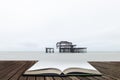 Landscape image of derelict Victorian West Pier at Brighton in West Sussex  in pages of open book, story telling concept Royalty Free Stock Photo