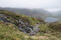 Landscape image of Llyn Idwal in Glyders mountain range in Snowdonia during heavy rainfall in Autumn