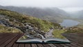 Landscape image of Llyn Idwal in Glyders mountain range in Snowdonia during heavy rainfall in Autumn coming out of pages of open Royalty Free Stock Photo