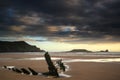 Landscape image of old shipwreck on beach at sunset in Summer