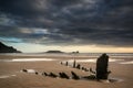 Landscape image of old shipwreck on beach at sunset in Summer