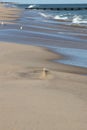 A landscape image of the shore in Rehoboth Beach, Delaware on a sunny afternoon. Seagulls and a jetty are in the background Royalty Free Stock Photo