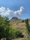 Landscape of an imposing volcanic mountain and sky cloud with various trees on the slope of the valley, Imbros Island,