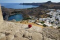 A red apple lies on the fortress wall in the ancient Acropolis of Lindos in August and a picturesque view of St. Paul\'s Bay. Royalty Free Stock Photo