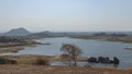 Landscape of Jawai dam with water, clear blue sky and Aravalli mountain ranges Royalty Free Stock Photo