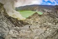 Landscape of the Kawah Ijen volcano with a sulfur miner hiking up the crater. Royalty Free Stock Photo