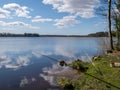 Landscape with a lake and beautiful cloud reflections, fishing accessories on the lake shore Royalty Free Stock Photo