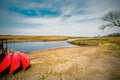 Landscape with lake,  blue cloudy sky and red canoes. Holidays on the river Narew in Poland. attractions of the Podlasie region. Royalty Free Stock Photo