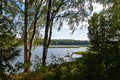 Landscape with lake, blue sky, clouds and trees. Beautiful nature landscape in a summer day Royalty Free Stock Photo