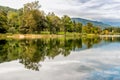 Landscape of Lake Ghirla with reflections of the clouds and trees, Italy