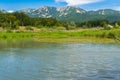 Landscape of lake, green vegetation forest and mountains the the foreground with blue sky - copysapce Royalty Free Stock Photo